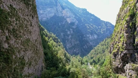 A narrow mountain gorge in summer, a drone flies through the gorge, the walls 库存影片 256331802