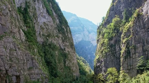 A narrow mountain gorge in summer, a drone flies through the gorge, the walls 库存影片 256331987