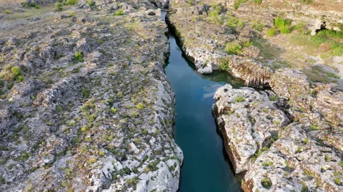 Narrow mountain river flowing through rocky landscape Stock Footage 133197491