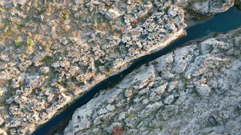 Narrow mountain river flowing through desolate rocky landscape Stock Footage 165367249