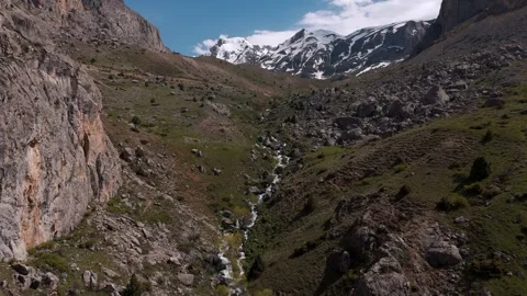 Narrow mountain valley with rocky cliffs framing both sides Vídeo Stock 338201088