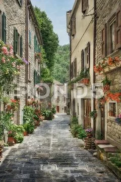 Narrow old street with flowers in Italy Stock Photos