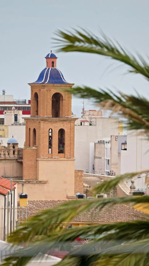 Narrow old-town street frames a blue-tiled church dome in Alicante, Spain. Stock Footage 316851776