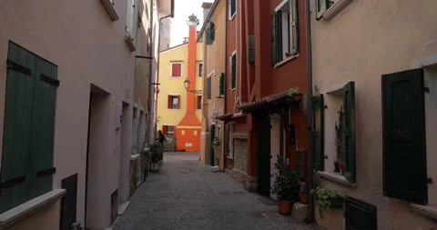 Narrow passage footpath between old colored buildings with a woman Stock Footage 150390948