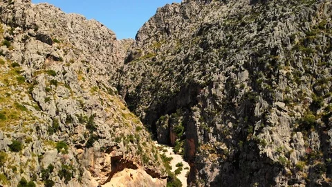 Narrow path between high rocky mountains. Sa Calobra, Majorca. 4K UHD aerial Stock Footage 121815796