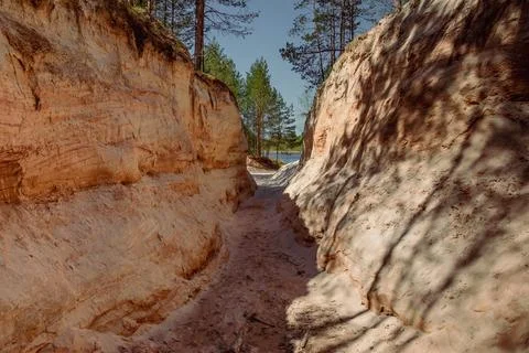 A narrow path between rocky cliffs with trees behind Stock Photos