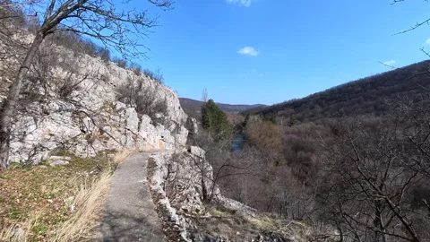Narrow path hugs steep rocky cliffside. Balkan, Eastern Europe, POV Vídeo Stock 331454353