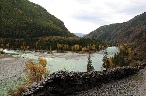 A narrow path with a stone wall overlooking the confluence of two beautiful r Stock Photos