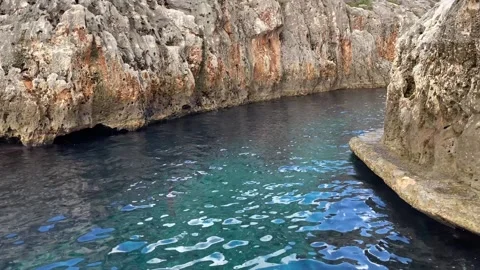 A narrow path under the rock leads towards the Blue Grotto. Coast of Malta. Stock Footage 263827919