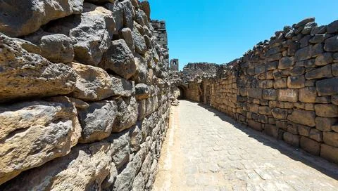 Narrow pathway between ancient stone walls Фото