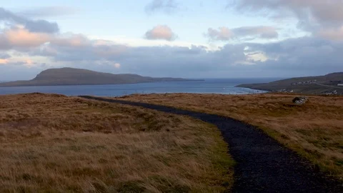 Narrow pathway on top of a hill facing sea, big mountainous island in background Stock Footage 92641219