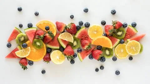 A narrow rectangle cluster of fresh fruit pieces against a white background. Stock Photos