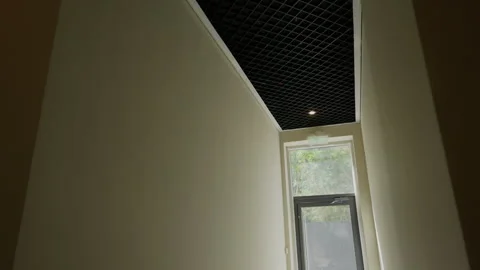 Narrow residential corridor with grid ceiling and window Stock-Footage 347214494
