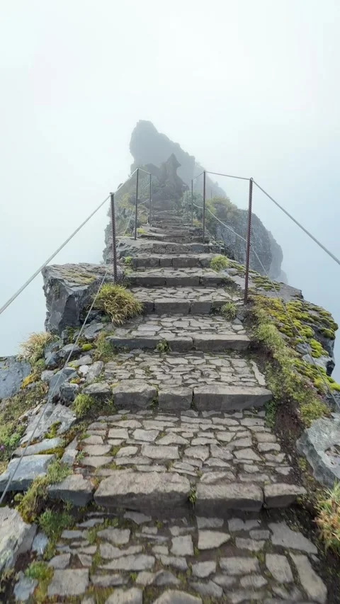 Narrow ridge trail with steep drops on both sides in fog on PR1 Madeira Stock Footage 331252141