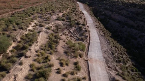 Narrow road between deserted mountains during the day Stock Footage 260078305