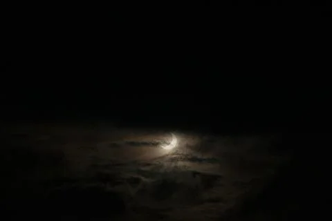 A narrow semicircle of the moon in cloudy cloudy weather. Sickle, crescent mo Fotos Stock