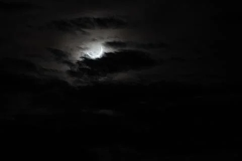 Narrow semicircle of solar disk during an eclipse in cloudy cloudy weather, E Stock Photos
