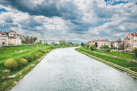 Narrow small river under cloudy rainy sky Foto stock