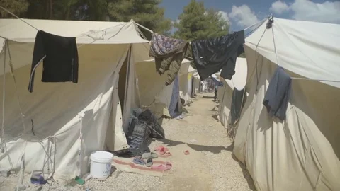 Narrow space between two rows of tents and clothes hanging out to dry Stock Footage 77449207