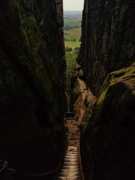 A narrow staircase leads down between two tall rock formations Stock Photos