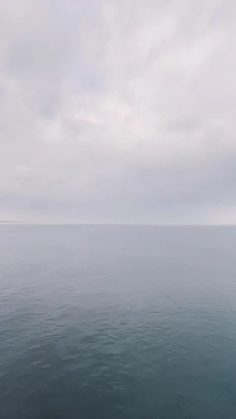 Narrow Vertical Seascape Under Cloudy Sky Stockbeeldmateriaal 344042473