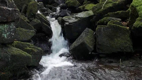 Narrow waterfall between moss covered boulders and large rocks background Video stock 69075470