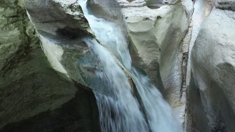 A narrow waterfall flowing over relief white rocks. Closeup view Stock Footage 158294381