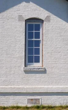 Narrow window on a white brick wall. Stock Photos