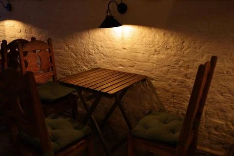 A narrowly focused lantern over a table in a dark cafe Stock Photos