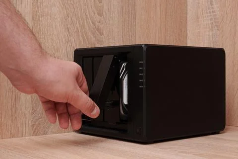 NAS server. Network storage. A man's hand opens a cell with a disk Foto stock