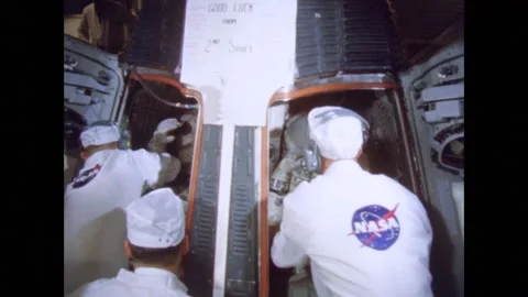 NASA engineers securing astronauts inside space capsule Stock Footage 263445551