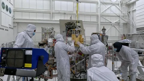 NASA technicians lowering Europa Clipper's SUDA instrument by hoist for assembly Stock Footage 289534451