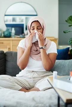 That nasty flu bug caught me. an attractive young woman sitting alone on her Stock Photos