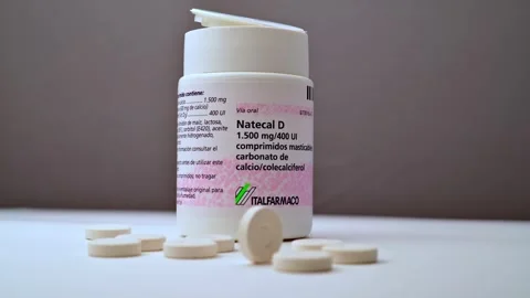 Natecal D Medication Bottle With Tablets On White Surface In Studio Lighting Stock Footage 325418074