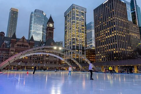 Nathan Phillips Square ice skating in Toronto city at dusk Stock Photos