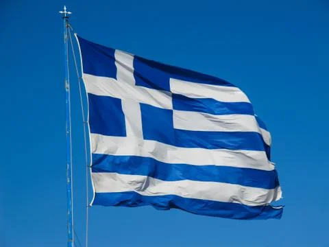 The national flag of Greece on the flagpole develops in the wind against the  Stock Photos