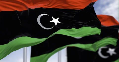 National flags of Libya waving on a clear day. Stock Illustration