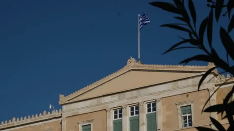 The national Greek flag is developing in the wind on the roof of the building of Video stock 301435516