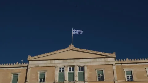 The national Greek flag is developing in the wind on the roof of the building of Video stock 301438701