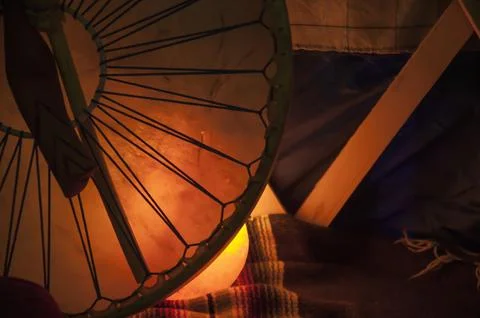 Native american drum with mallet lighting up tipi at night Stock Photos