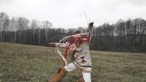 Native American falls to the ground and rolls back across the field Stock Footage 124209725