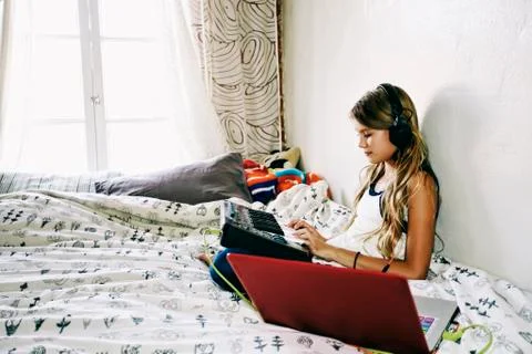 Native American girl recording music on bed Stock Photos
