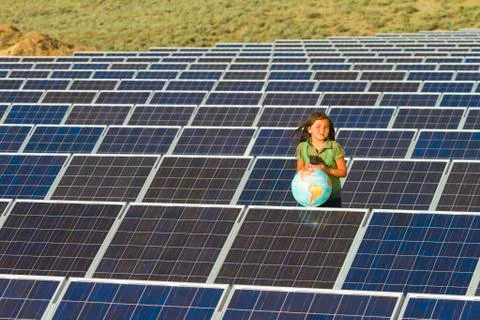 Native american girl standing near solar panels holding globe Stock Photos