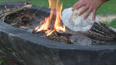 Native American Indian man using primitive tools and fire to dig out log canoe Stock Footage 98782797