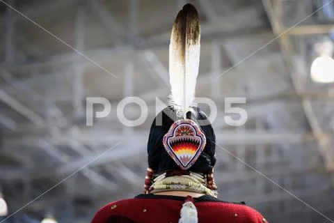 Native American Indian woman in a traditional outfit with an eagle feather in Stock Photos