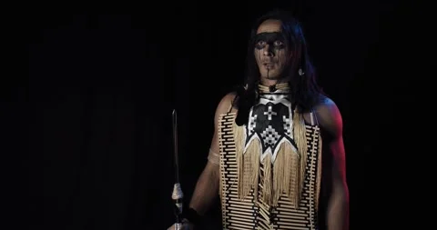 Native american man is jumping, spreading his arms and looking at the sky, 4k Stock Footage 136077636