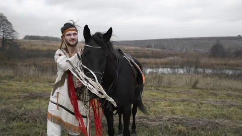 Native American turns around and holds his horse Stock Footage 124210872
