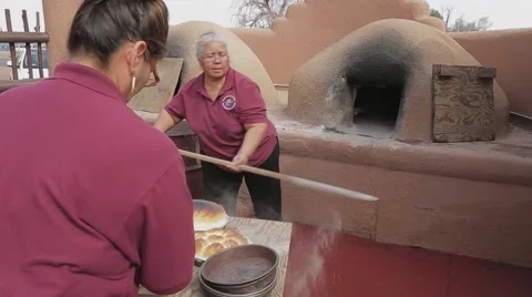 Native American Women taking bread out of Hornos Oven Stock Footage 41795433