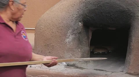 Native American Women taking bread out of Hornos Oven Stock Footage 41795436