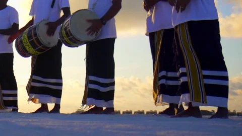 Native local men play drums and music at a tropical island resort hotel at sunse Stock Footage